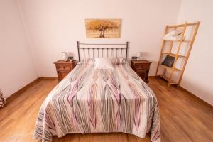 a bedroom with a bed with a striped comforter at Villa Ortega Alba in Alcalá la Real +37 photos