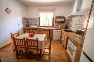 a kitchen with a table and chairs and a kitchen with a stove at Villa Ortega Alba in Alcalá la Real