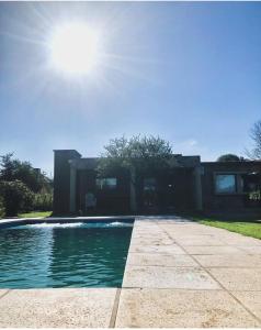 a house with a swimming pool in front of it at Casa en Santa Rosa de Calamuchita in Santa Rosa de Calamuchita