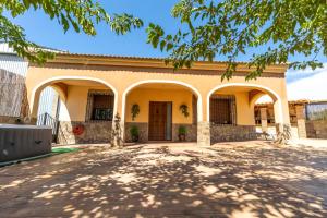 a yellow building with arches and a driveway at Villa Ortega Alba in Alcalá la Real