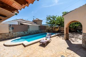 a swimming pool with a chair next to a house at Villa Ortega Alba in Alcalá la Real