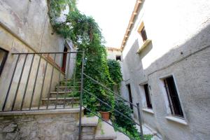 エーリチェにあるLa scalettaの階段と蔦が生える古い建物