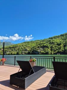 a balcony with two chairs and a view of the water at "Vista Paradiso" - Jaz - lake view in Višegrad