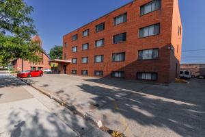 a red car parked in front of a brick building at Aisling Hotel in Great Falls