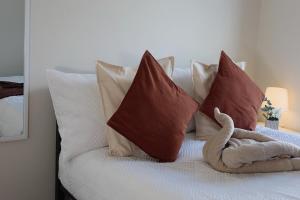 a bed with pillows and a stuffed animal sitting on it at Newcastle City Centre Apartment with Free Private Parking, Walk Away to Quayside in Newcastle upon Tyne