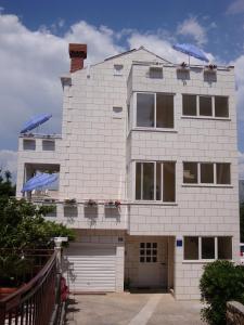 una casa de ladrillo blanco con garaje en Apartments Dadic Cavtat, en Cavtat
