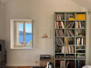 ein Bücherregal voller Bücher neben einem Fenster in der Unterkunft Fortuna House Vis in Vis