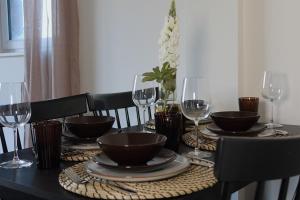 a black table with wine glasses and plates on it at Newcastle City Centre Apartment with Free Private Parking, Walk Away to Quayside in Newcastle upon Tyne +15 photos