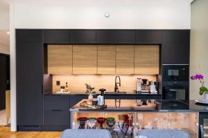 RovaniemiにあるModern Lapland Hideaway By BookLaplandのキッチン(黒いキャビネット、カウンター付)