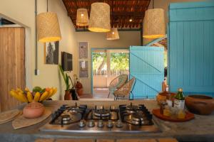 a kitchen with blue cabinets and a stove top oven at Casa Cajuzal Carrapateira in Acaraú