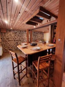 a dining room with a wooden table and chairs at Le Moulin de la Hire in Miremont +14 photos