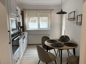 a kitchen with a table and chairs in a room at The Cozy Nest in Carei