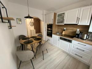 a kitchen with a table and chairs in a room at The Cozy Nest in Carei