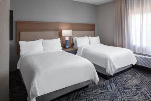 a hotel room with two beds and a window at Candlewood Suites St. Robert by IHG in Saint Robert +30 photos