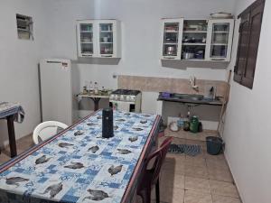 a kitchen with a table with a table cloth on it at Casas Aluguel Temporada Pousada Village Maçarico in Salinópolis +6 photos