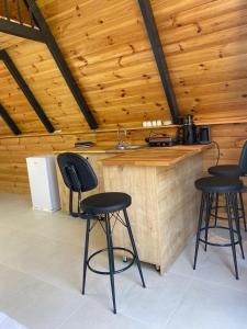 a kitchen with a counter with three bar stools at Honey Bungalow Kartepe - With Hot Pool in Kartepe