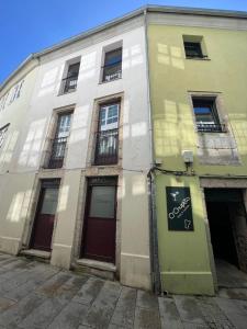 ルーゴにあるApartamentos muralla de Lugoの通りに面した窓のある白い建物