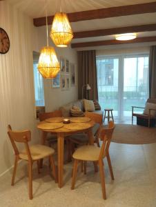 a living room with a table and chairs and a couch at Apartament -Podczele in Kołobrzeg