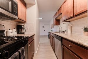 a kitchen with wooden cabinets and a stove at Central PHX Deluxe 1 BR King Bed & Patio w Pool in Phoenix