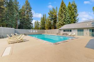 una piscina con sillas y una valla en Hidden Village 700, en Big Sky