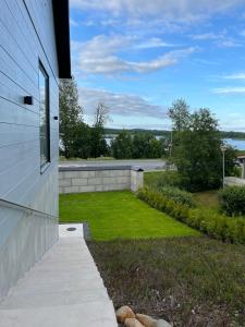 a house with a lawn next to a building at New gorgeous semi-detached house in Lempäälä