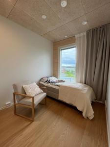 a bedroom with a bed and a window and a chair at New gorgeous semi-detached house in Lempäälä