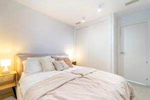 a white bedroom with a large bed with pillows at Mara's Apartments Higuerón West -Blue Horizon - Seaviews in Fuengirola