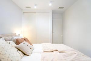 a bedroom with a bed with white sheets and pillows at Mara's Apartments Higuerón West -Blue Horizon - Seaviews in Fuengirola