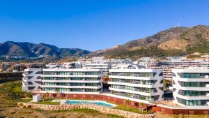 a large white building with a pool in front of a city at Mara's Apartments Higuerón West -Blue Horizon - Seaviews in Fuengirola +20 photos