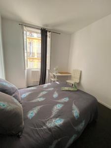 a bedroom with a bed and a table and a window at Cozy room in the heart of Marseille in Marseille