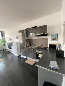 a kitchen with stainless steel appliances and a black floor at Cozy room in the heart of Marseille in Marseille +3 photos