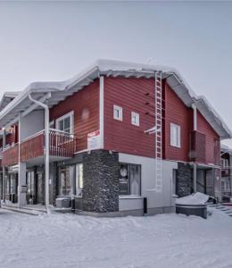 a large red building with snow on the ground at Levi Nordic Light in Levi