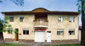 a large stone building with a balcony and a garage at Euro Panzio in Debrecen