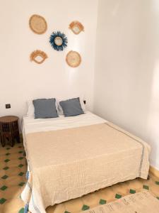a bedroom with a bed with hats on the wall at Riad Marocain avec jacuzzi sur la terrasse entièrement louer avec 3 chambres pour 6 personnes dans la médina proche de la place Jemma el fna in Marrakech +28 photos