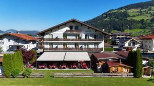 a large white building with a balcony in a village at Hotel Alpenhof in Westendorf