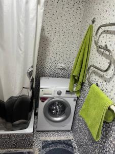 a washing machine in a bathroom next to a shower at Вип Квартира посуточно in Shakhtīnsk
