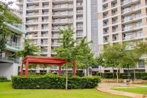 a red structure in a park in front of a tall building at Menlyn Maine Luxury Apartments - Penthouse 1217 in Pretoria