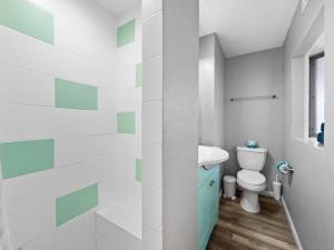 a bathroom with a toilet and a sink at Trendy & Relaxing - Close to Beach - Pool - Hot Tub in Sarasota +20 photos