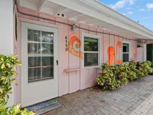 a pink house with a white door and windows at Trendy & Relaxing - Close to Beach - Pool - Hot Tub in Sarasota