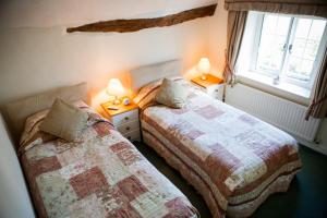 two beds sitting next to each other in a bedroom at Farmhouse Cottage in Sidmouth