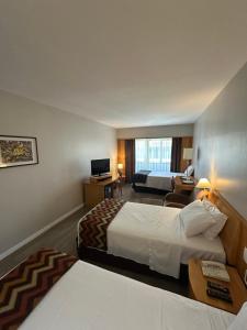 Una habitación de hotel con dos camas y un televisor. en Hotel & Residence Sol Alphaville Flat, en Barueri