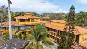 an aerial view of a yellow building with palm trees at POUSADA ELOHIM DE BUZIOS in Búzios