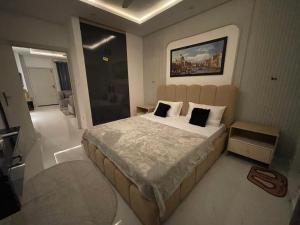 a bedroom with a large bed with two pillows at The Greystone Luxe in Rawalpindi +9 photos
