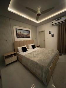 a bedroom with a large bed with a ceiling at The Greystone Luxe in Rawalpindi