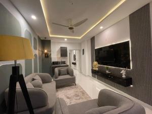 a living room with couches and a flat screen tv at The Greystone Luxe in Rawalpindi