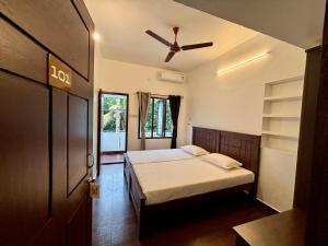 Un dormitorio con una cama y un ventilador de techo. en Fort Grande Stay, en Kochi