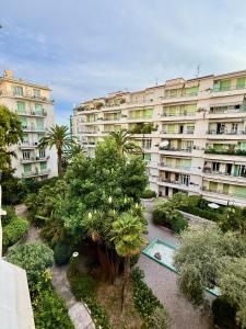 a large apartment building with a garden in front of it at Promenade Chic Apartment Sea & City in Nice