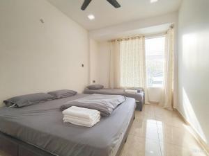 a bedroom with two beds and a large window at MiuMiu Homestay in Teluk Intan