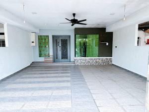 an empty room with a ceiling fan and a door at MiuMiu Homestay in Teluk Intan