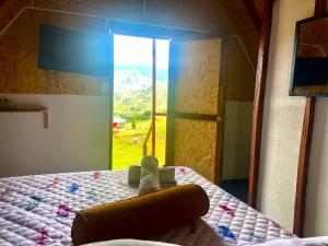 a teddy bear sitting on a bed in a bedroom at Hotel Cabañas Villa Loe Jardín in Jardin